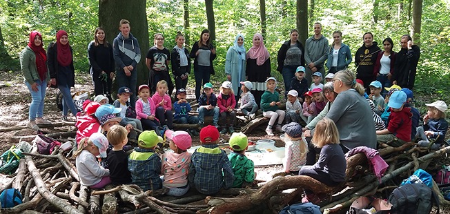 Foto: Die angehenden Kinderpflegerinnen und Kinderpfleger des Berufskollegs Dinslaken (hinten) mit den Kindern des Kindergartes St. Johannes und ihren Betreuerinnen.